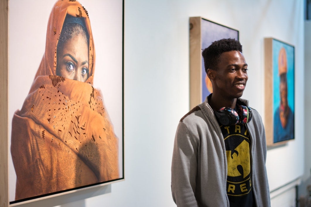 Papay in front of his work displayed on a gallery wall