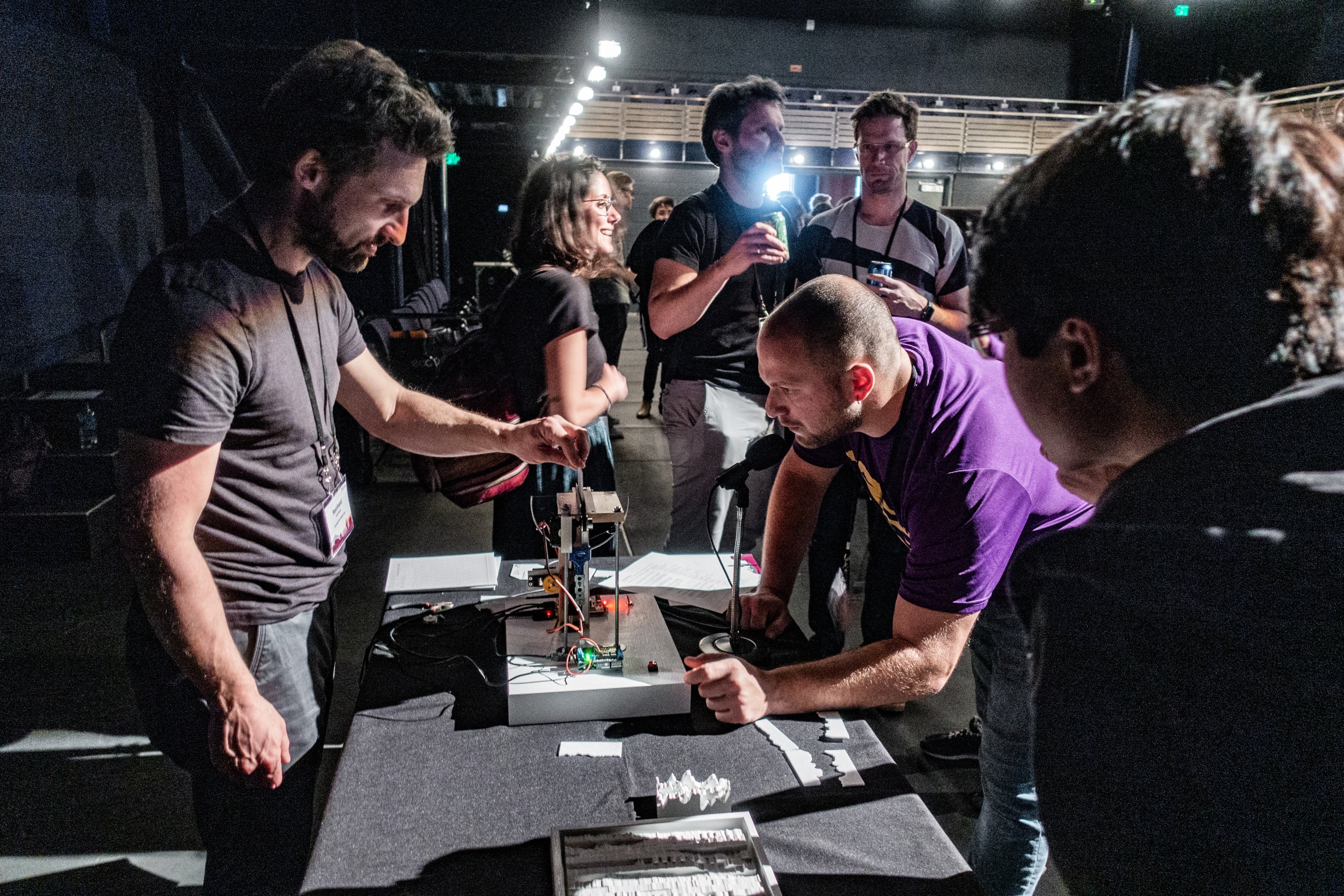 man speaks into microphone that interacts with small device on table